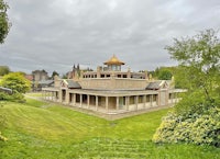 a large building in the middle of a grassy area